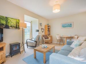 een woonkamer met een blauwe bank en een open haard bij 1 Bed in Matterdale SZ222 in Watermillock