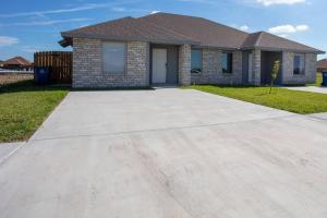 a house with a driveway in front of it at Luxurious & Comfy near SpaceX Starbase with Desks in Brownsville