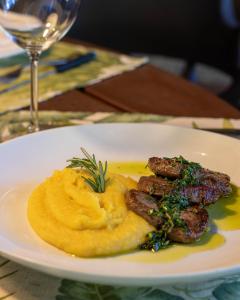 un plato de comida con carne y puré de patatas en una mesa en Kastel Pedra Bonita, en Petrópolis