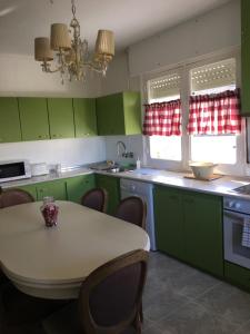 una cocina con armarios verdes y una mesa con sillas en Chalet Camino Verde, 