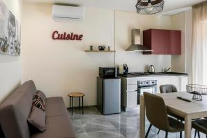 Il comprend une cuisine et un salon avec une table et une cuisinière. dans l'établissement PICCOLO PARADISO Suite LUNA, à Scafa