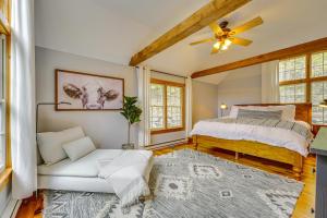 een slaapkamer met een bed en een bank bij Picture-Perfect Vermont Mtn Cabin with Hot Tub! in Bridgewater