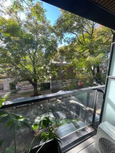 a window view of a garden from a balcony at Departamento Nuevo en Palermo Soho in Buenos Aires