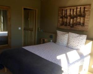 ein Schlafzimmer mit einem Bett mit einer blauen Decke und Kissen in der Unterkunft Une Sieste en Luberon in Bonnieux