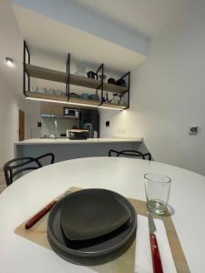 a black plate sitting on a table with a glass at Departamento Nuevo en Palermo Soho in Buenos Aires