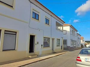 a row of white buildings on a street at Casa Jasmim - charming houses - Alojamento Local - perto Zambujeira do Mar in São Teotónio