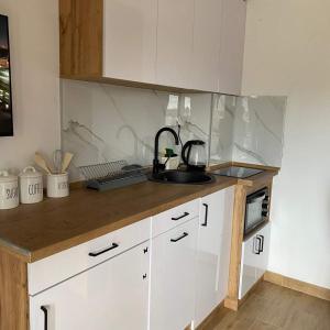 a kitchen with white cabinets and a sink at Apartman Andjela in Herceg-Novi