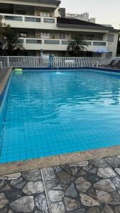 a large blue swimming pool in front of a building at Quintal do forte in Praia Grande