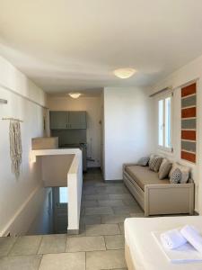 Agnadi Syros Beachfront Studios & Rooms في Megas Gialos - Nites: غرفة معيشة مع أريكة ومطبخ