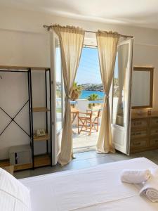 een slaapkamer met een bed en uitzicht op de oceaan bij Agnadi Syros Beachfront Studios & Rooms in Megas Gialos - Nites