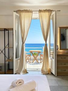 Agnadi Syros Beachfront Studios & Rooms في Megas Gialos - Nites: غرفة نوم مطلة على المحيط