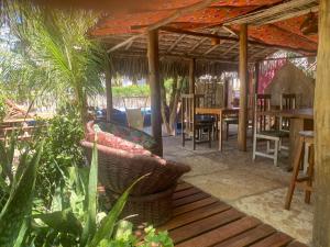 un patio con tavolo, sedie e piante di Caju Bangalôs a Ponta do Anel