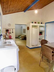 una cucina con frigorifero, tavolo e sedie di Chalé com 2 quartos na Beira do Lago Pet Friendly a Posse Altre 19 foto