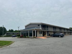 グリーンズボロにあるBravo Inn Greensboroの駐車場に車が停まっている建物