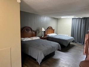 a hotel room with two beds and a window at Bravo Inn Greensboro in Greensboro