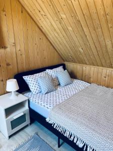 a bed in a room with a wooden ceiling at Baltic Star in Władysławowo