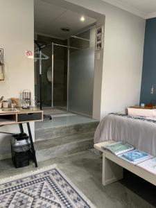 a bedroom with a shower and a bed and a table at Modern Stylish room Linkside in Mossel Bay