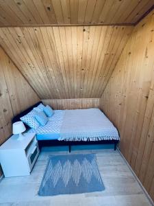 a bed in a room with a wooden ceiling at Baltic Star in Władysławowo