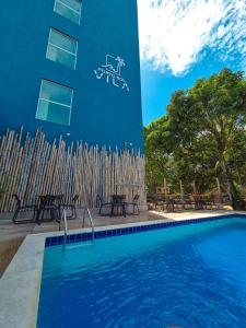 a building with a swimming pool in front of a building at Porto Vila by AFT in Porto De Galinhas