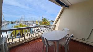 a balcony with a table and chairs and a marina at super appartement vue port Camargue- Le Grau Du Roi in Le Grau-du-Roi