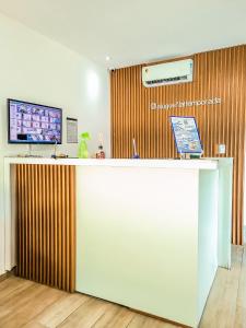 a lobby with a counter with a television above it at Porto Vila by AFT in Porto De Galinhas