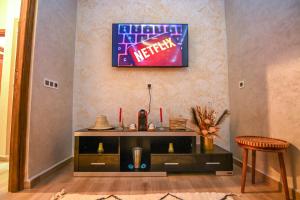 a living room with a table and a sign on the wall at The Skyline Stay in Marrakech