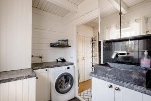 een keuken met een wasmachine en een wastafel bij 3 Bedroom Cottage with Sauna by the Sea in Vaasa