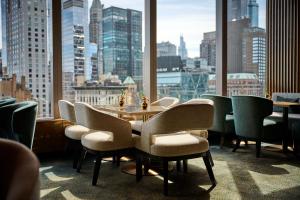 a dining room with a table and chairs and a large window at Mandarin Oriental, New York in New York