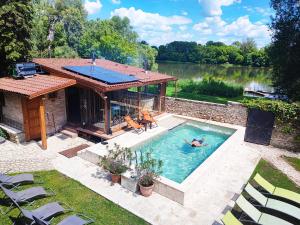 a swimming pool with two people in a house at Vízparti Apartmanház in Leányfalu