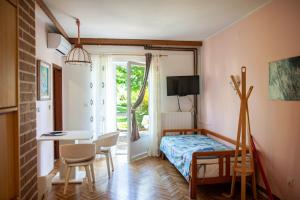 una camera con letto, scrivania e tavolo di Apartments Marija a Murine