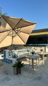 拿索的住宿－Sun Fun Hotel，长凳和一张带雨伞的桌子