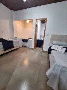a room with two beds and a room with two beds at Suítes Pitangueiras - POUSADA FRENTE MAR in Guarujá