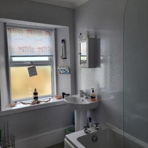 a bathroom with a sink and a window at RAWSON COTTAGE LOVELY 2 BEDROOM SEMI RURAL in Stranraer