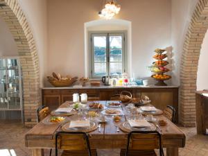 comedor con mesa de madera y sillas en I Casali del Pino, en La Giustiniana