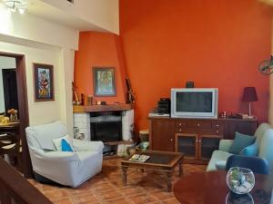 a living room with a tv and a fireplace at Casa Jasmim - charming houses - Alojamento Local - perto Zambujeira do Mar in São Teotónio