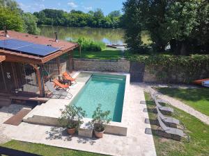 Una piscina en un patio con un cenador. en Vízparti Apartmanház, en Leányfalu