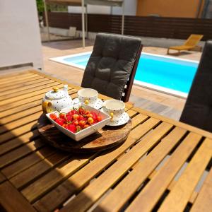 ein Tisch mit einer Schüssel Tomaten darauf in der Unterkunft SunN Joy in Kaštela