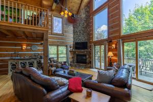 Una sala de estar con muebles de cuero y chimenea. en Cari's Rivers Edge, en Valle Crucis