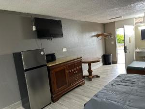 a kitchen with a refrigerator and a table in a room at Bravo Inn Greensboro in Greensboro