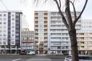 a large building with cars parked in front of it at Porto River Sunset 1st in Vila Nova de Gaia