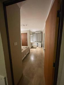 Habitación vacía con cama y pasillo en Hotel Fazenda Santa Monica, en Louveira