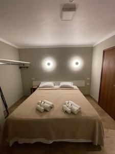 1 dormitorio con 1 cama con 2 toallas en Hotel Fazenda Santa Monica, en Louveira