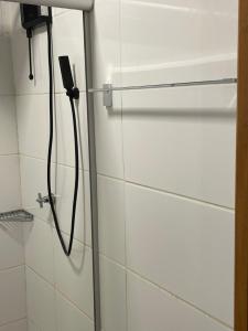 una ducha con una manguera pegada a la pared en Hotel Fazenda Santa Monica, en Louveira