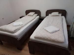 two beds in a room with towels on them at TSG Apartaments in Valea lui Mihai