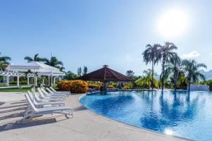 uma fila de espreguiçadeiras junto a uma piscina em Daj Resort & Marina em Ribeirão Claro