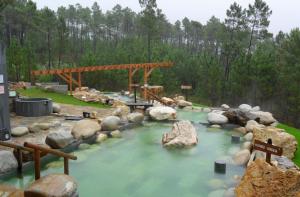 un río con rocas y un puente de madera en casa ribeiro 1, en Ribadavia