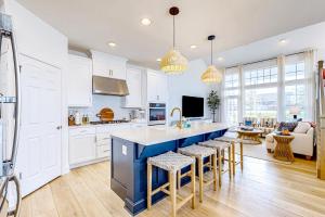 a kitchen with white cabinets and a blue island with bar stools at Marlin Chase --- 30266 Kona Dr in Ocean View