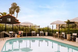 una piscina en un hotel con sillas y sombrillas en Sonder Woods Cove, en Laguna Beach
