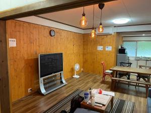 a living room with a flat screen tv on a wooden wall at Kojinjuku - Vacation STAY 46728v in Setouchi