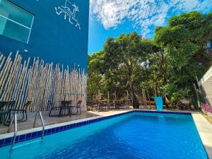 a pool in front of a building with chairs and tables at Porto Vila by AFT in Porto De Galinhas
